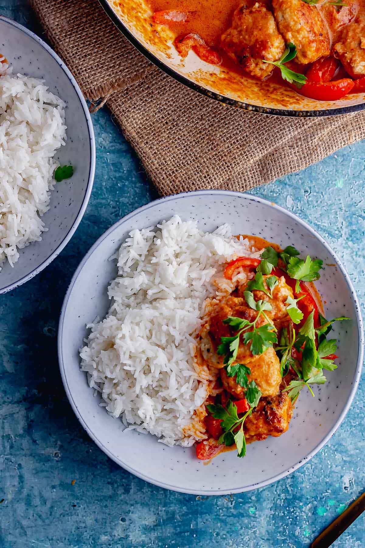 Overhead shot of a blue bowl of Thai turkey meatball curry with rice