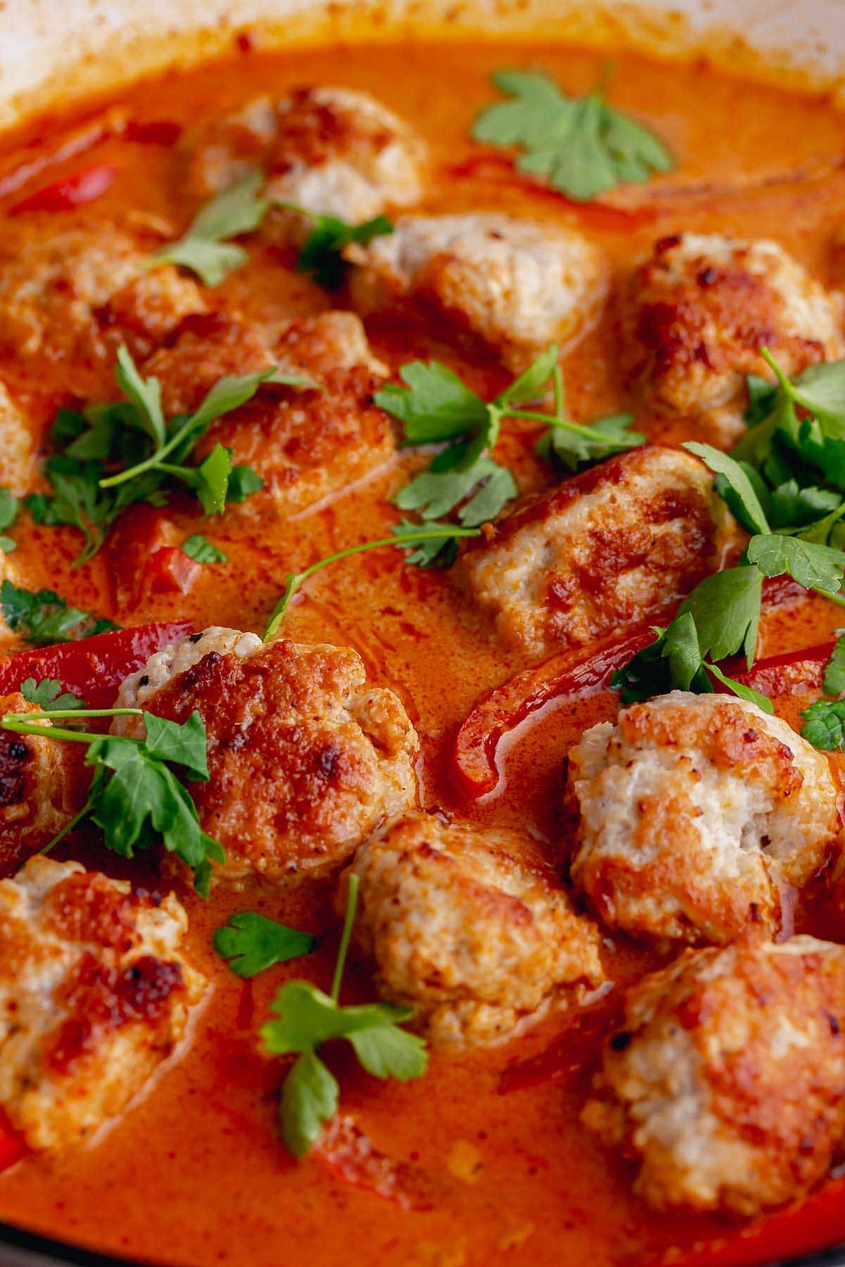 Close up of turkey meatballs in Thai red curry