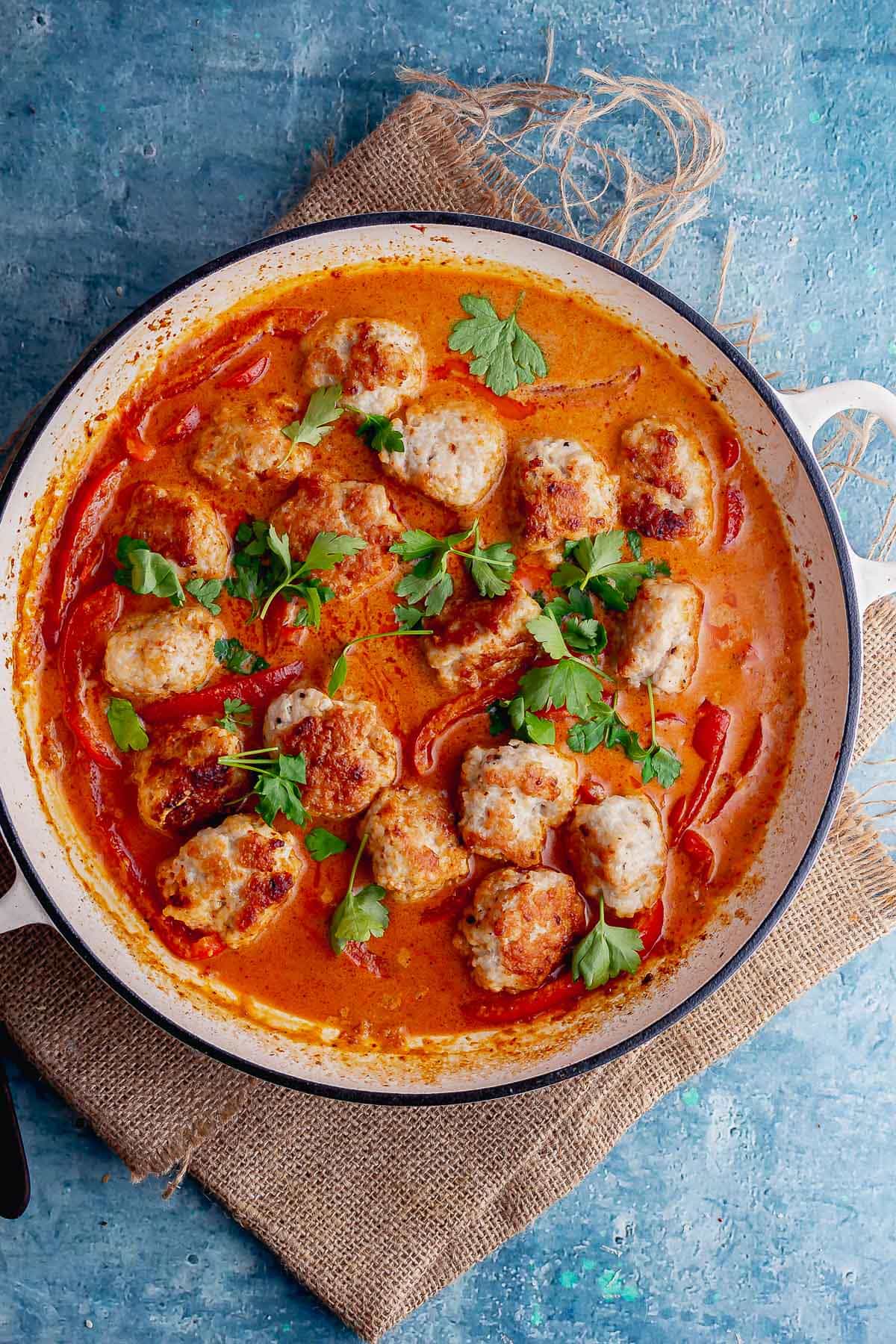 Overhead shot of Thai curry with meatballs on a blue background