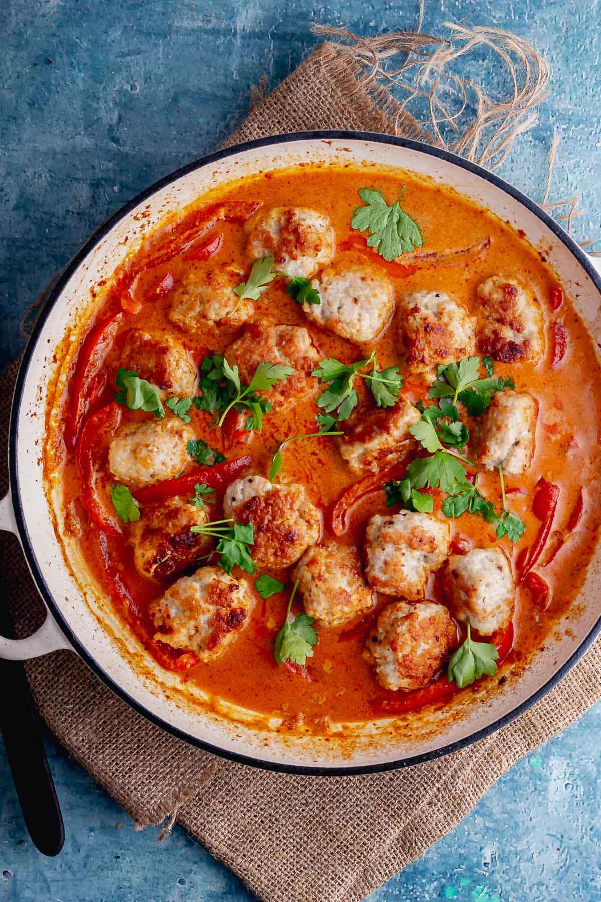 Overhead shot of Thai meatball curry on a blue background