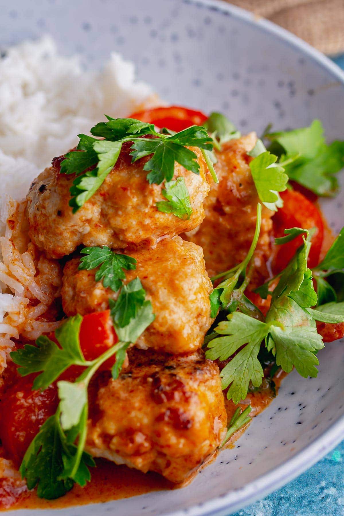 Close up of turkey meatballs in Thai curry sauce 