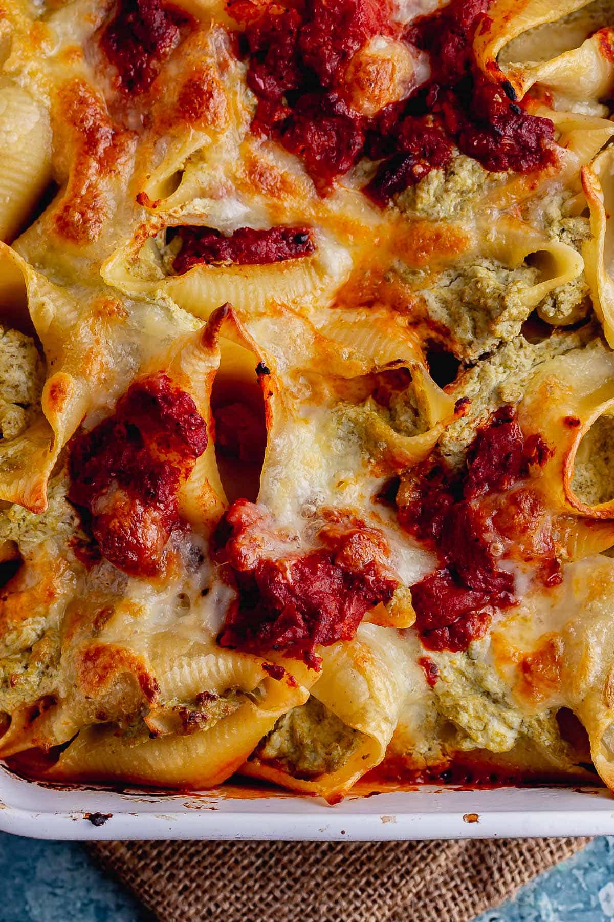 Close up of pesto pasta bake with tomato sauce