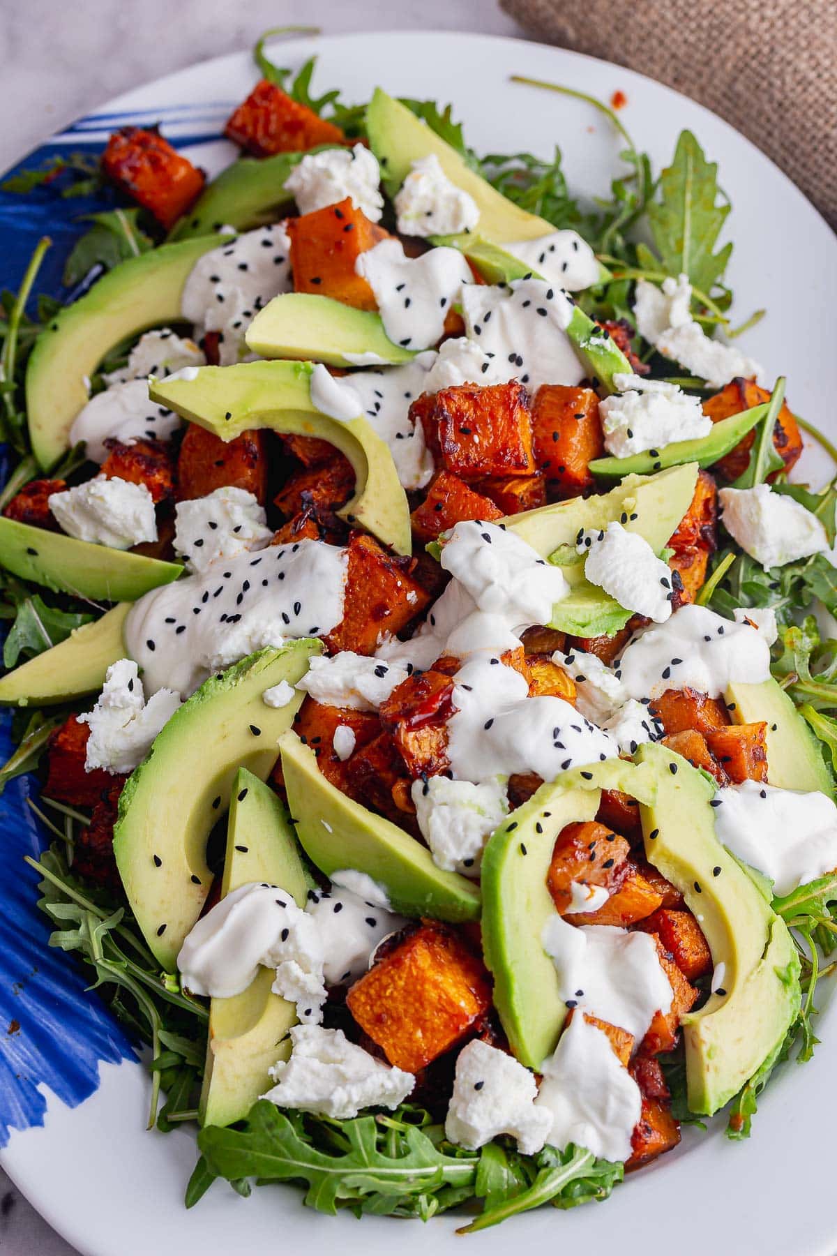 Platter of spicy squash salad topped with avocado