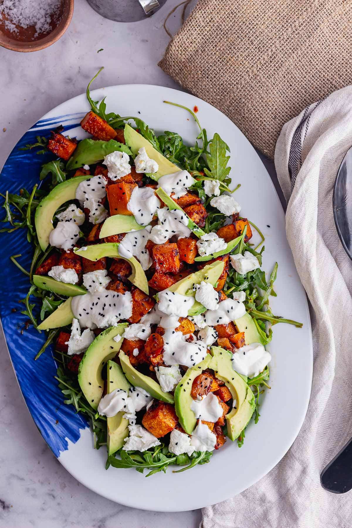 Overhead shot of spicy squash salad on a marble background