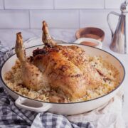 White dish of stuffed chicken and risotto on a checked cloth