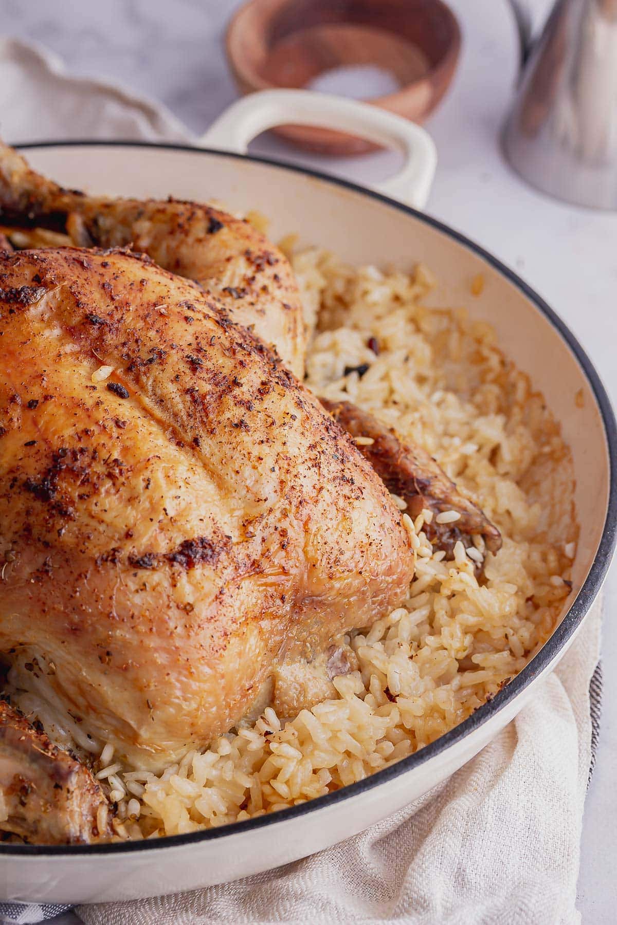 Close up of roast chicken on rice in a white dish