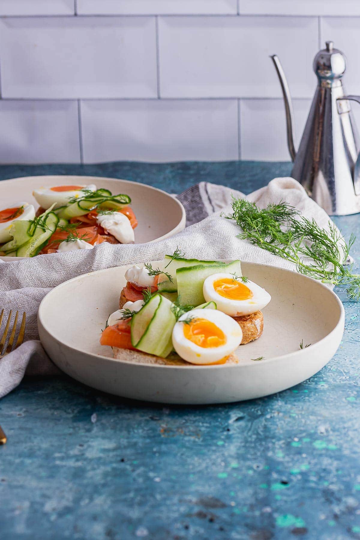 Side shot smoked salmon toasts with eggs on a blue background