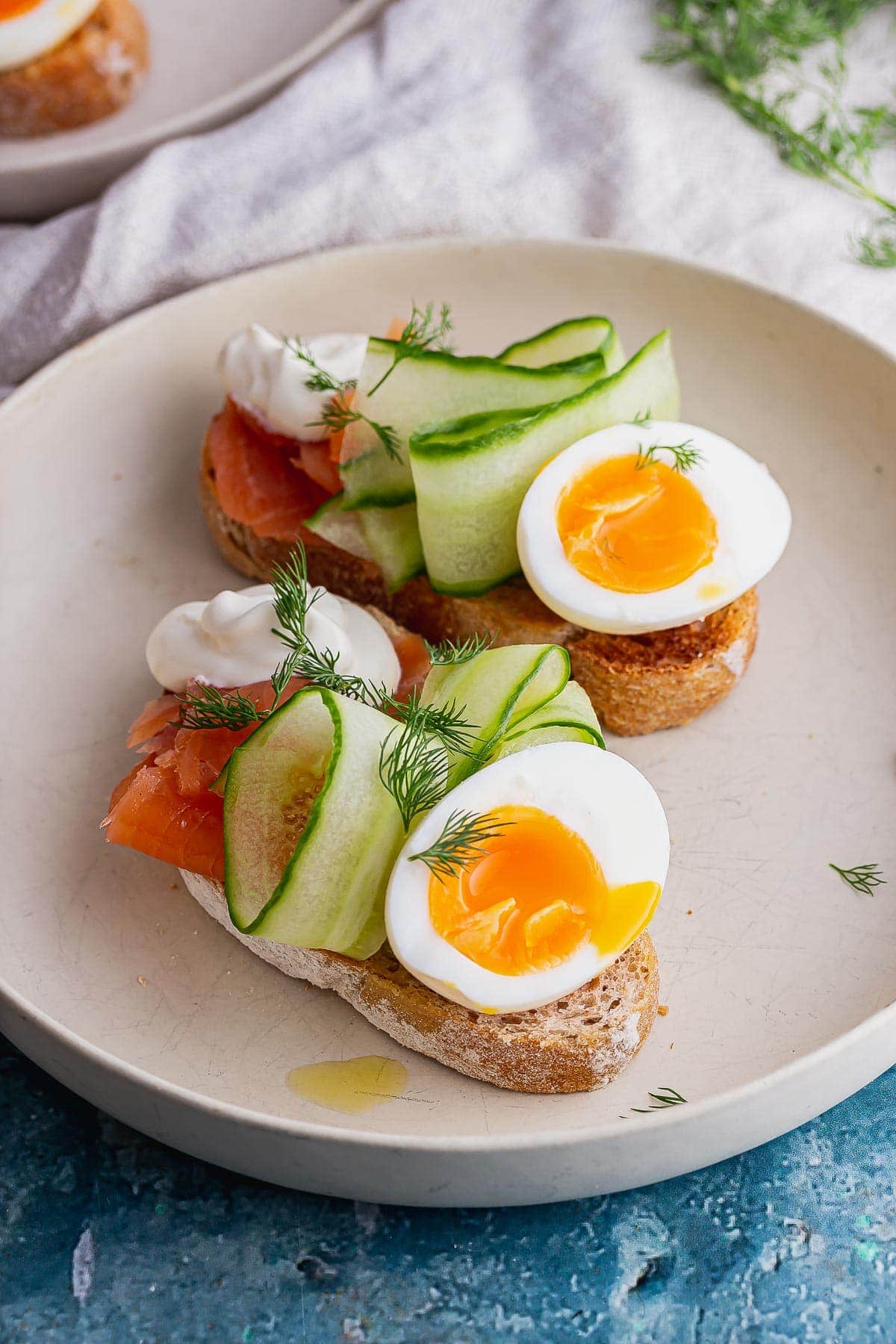 White bowl with salmon toasts on a blue background