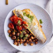 Overhead shot of fried sea bass and chickpeas in a blue bowl