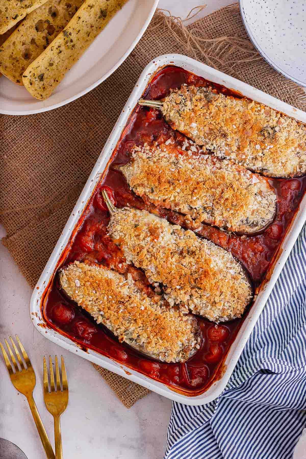 Overhead shot of eggplant topped with breadcrumbs in a red sauce