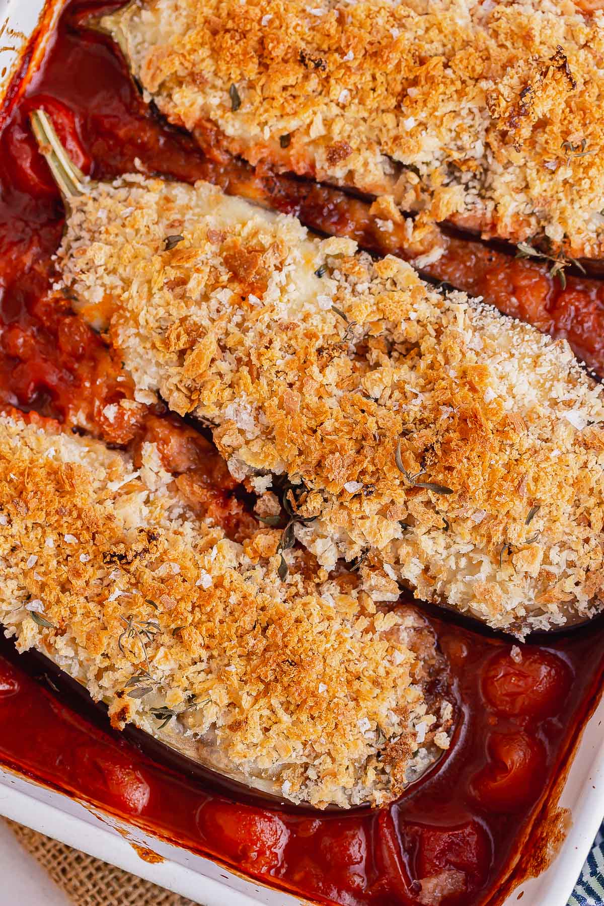 Close up of aubergine topped with breadcrumbs in a tomato sauce