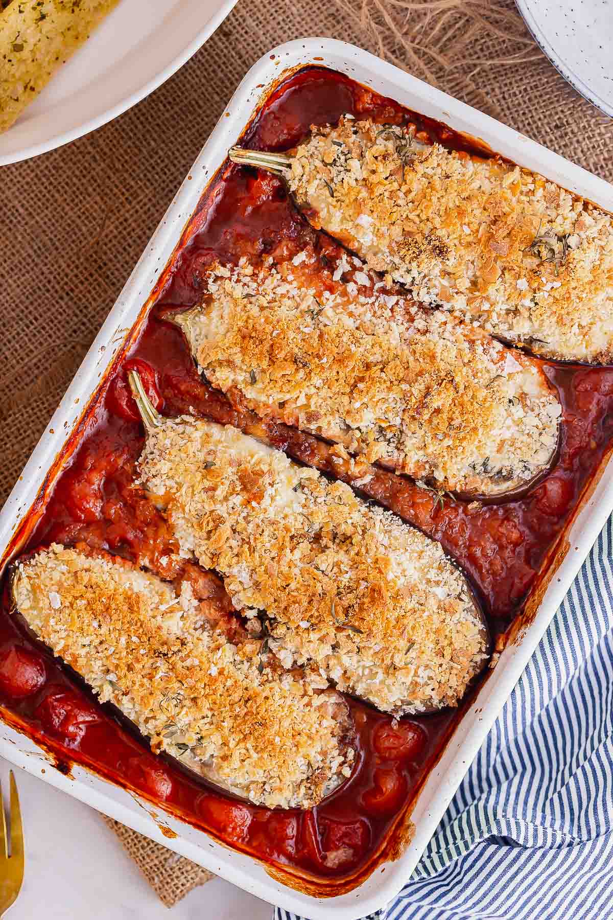 Overhead shot of panko topped aubergine in a red sauce