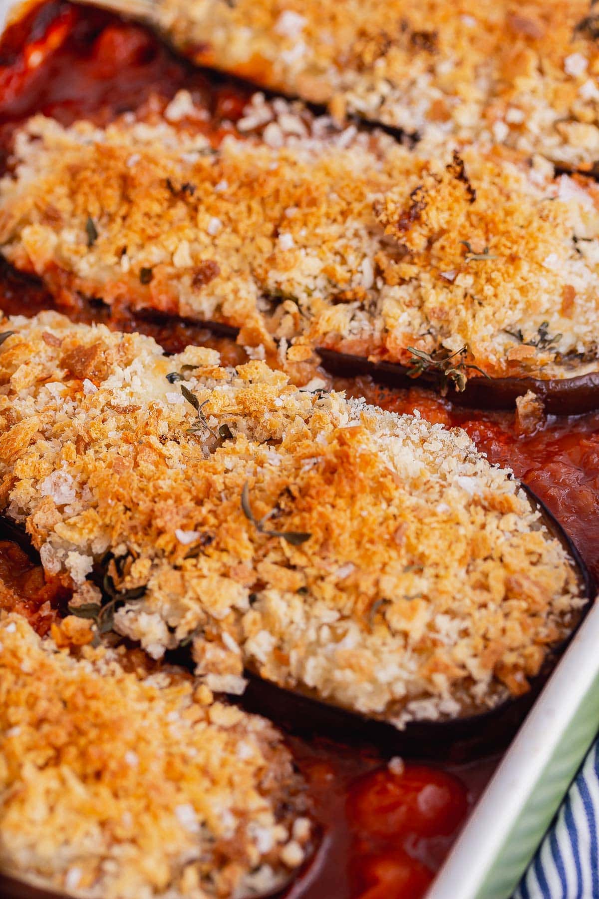 Close up of crunchy topped aubergines in tomato sauce