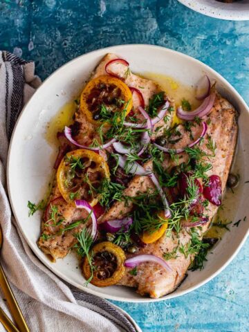Overhead shot of buttery trout with lemon and red onion