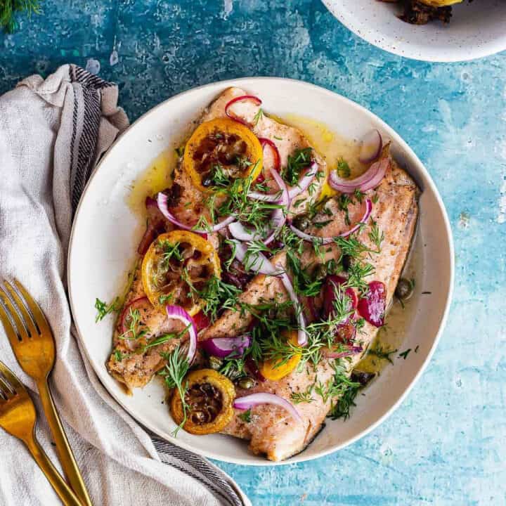Overhead shot of buttery trout with lemon and red onion