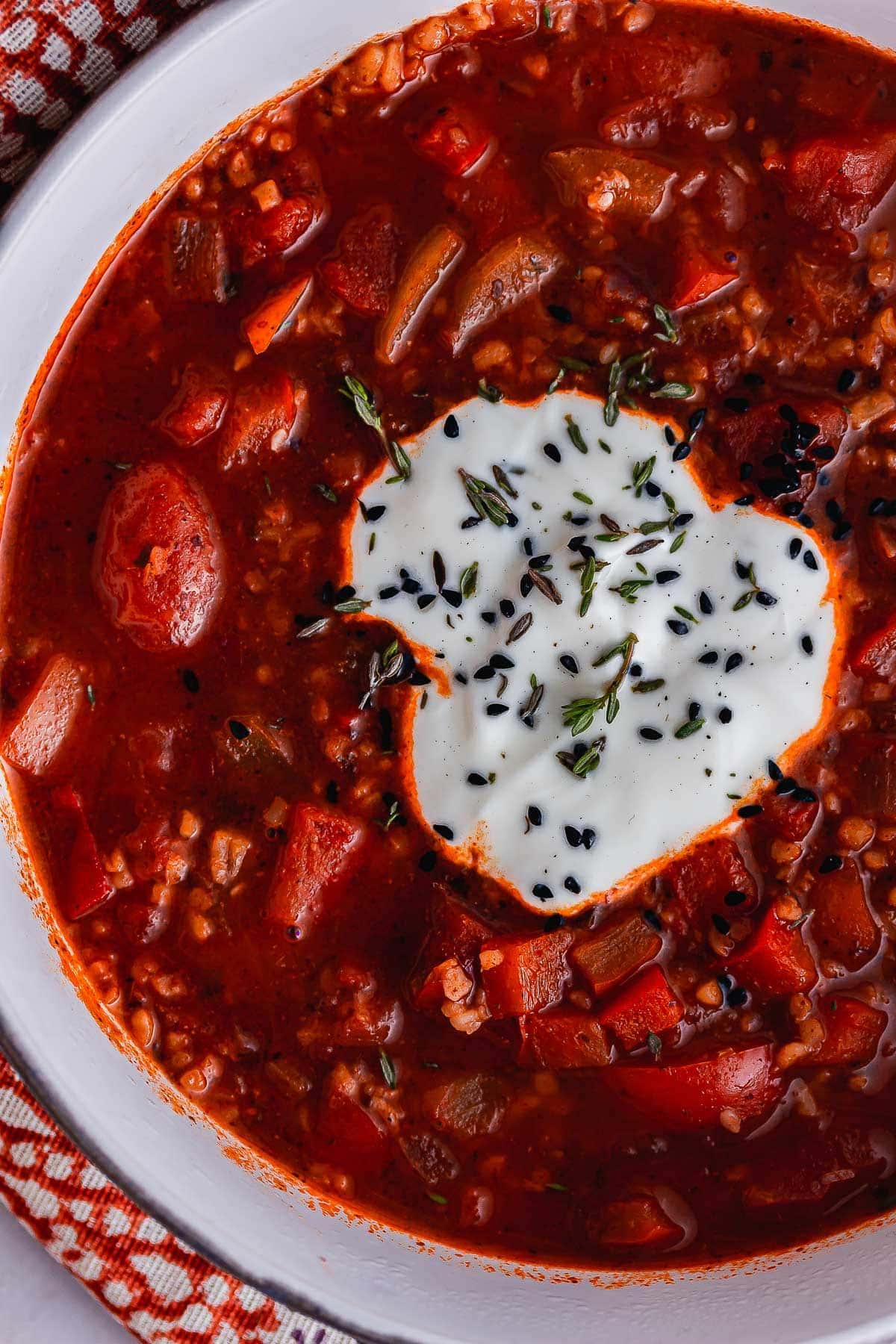 Overhead shot of tomato and bulgur soup topped with yoghurt