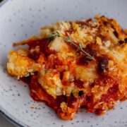 Close up of cauliflower and tomato bake in a blue bowl