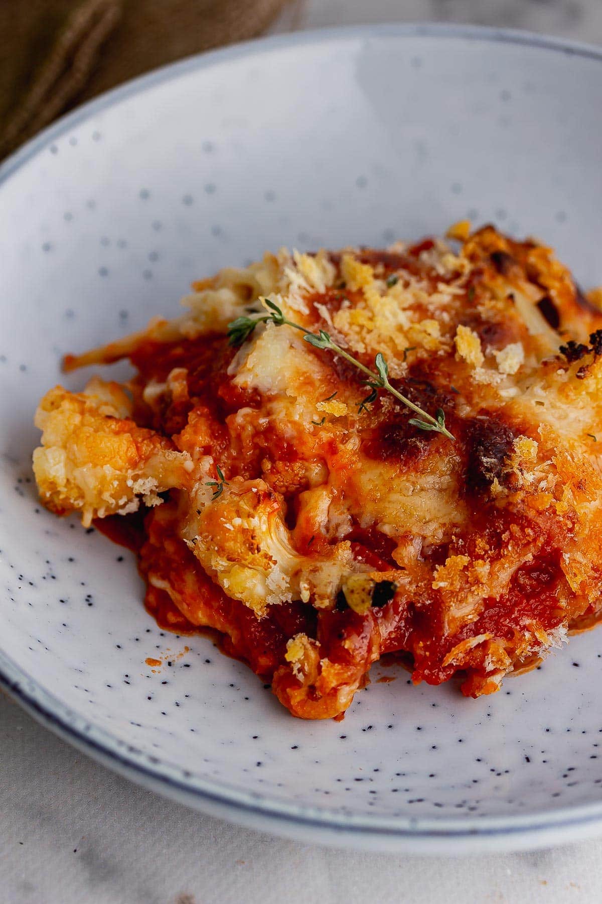 Close up of cauliflower and tomato bake in a blue bowl