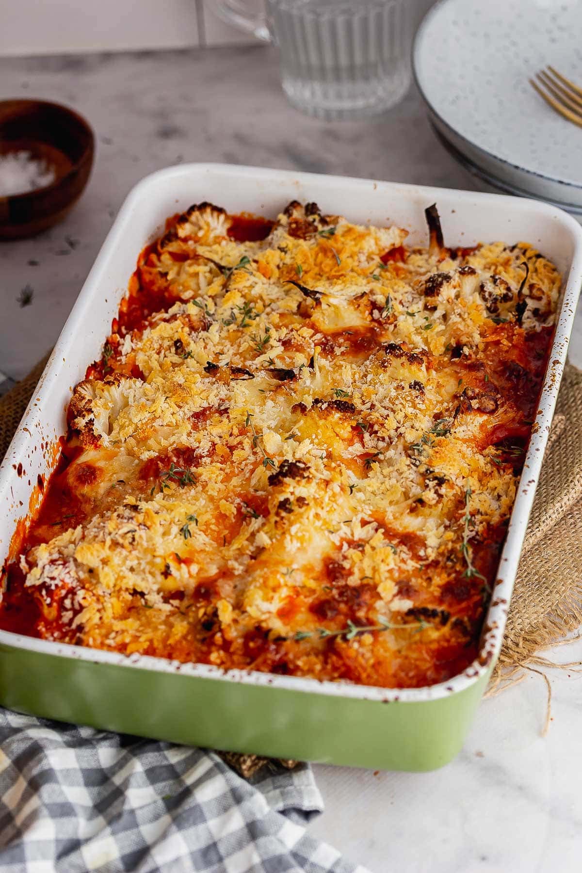 Greek baking dish of cauliflower cheese bake with a checked cloth