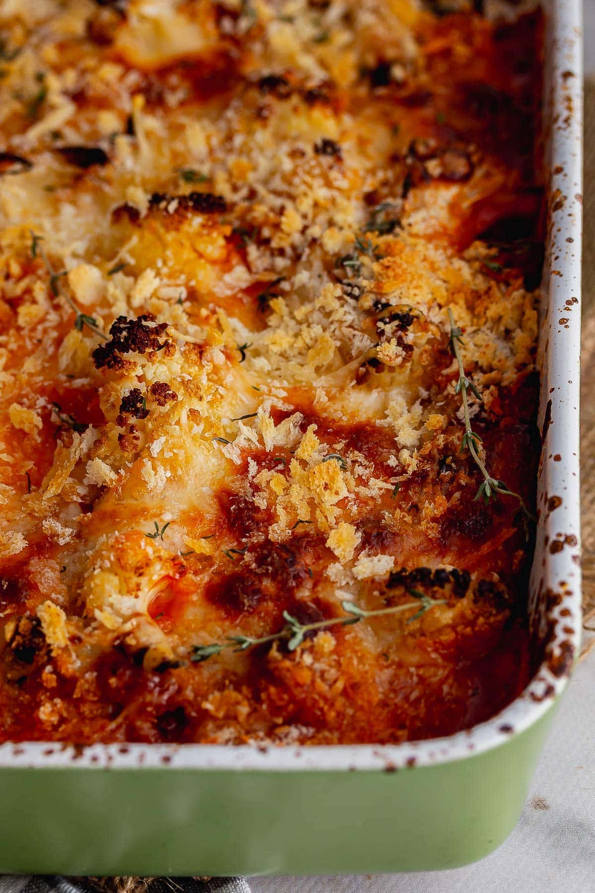 Green baking dish of cheesy cauliflower bake