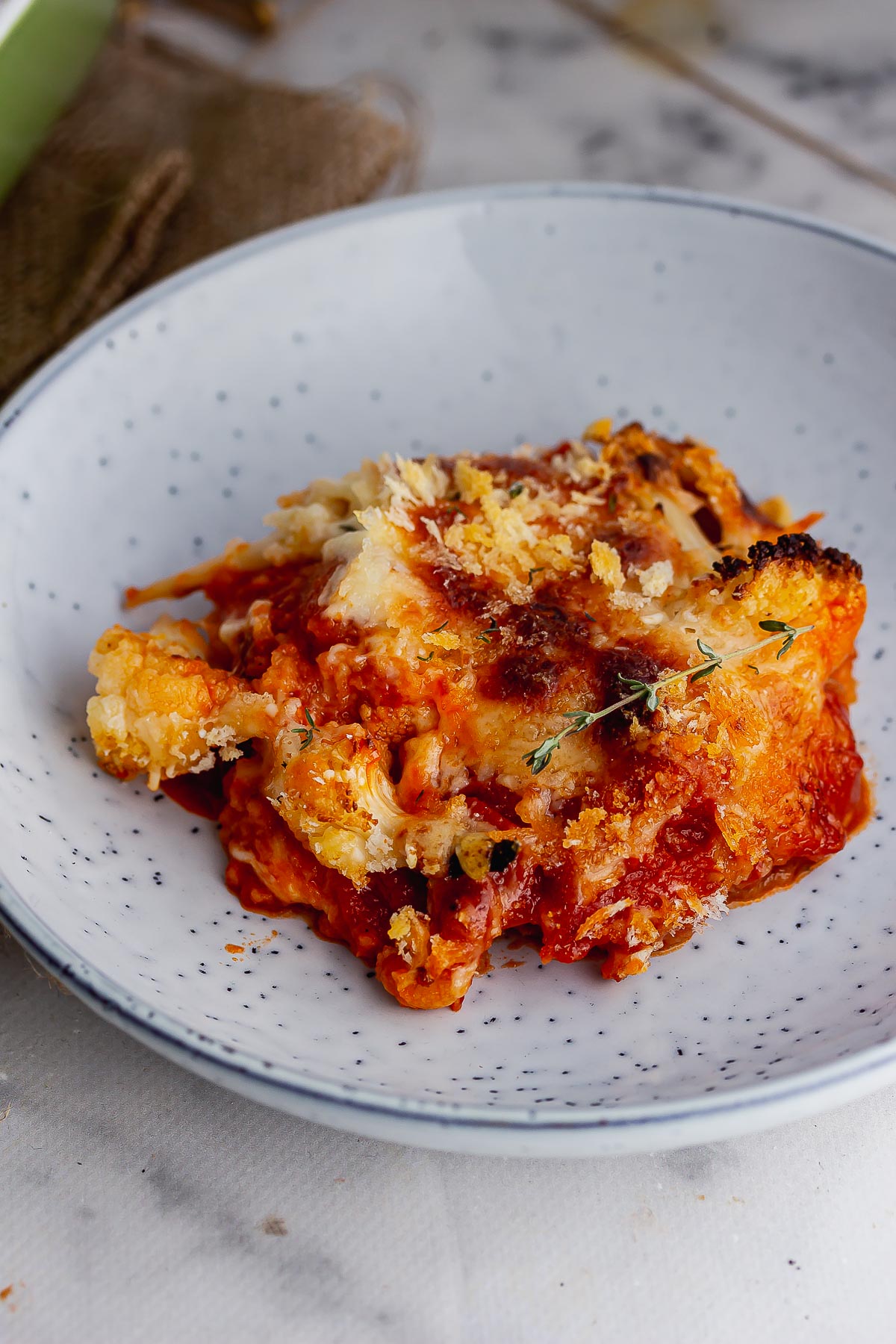 Blue bowl of cauliflower bake on a marble surface