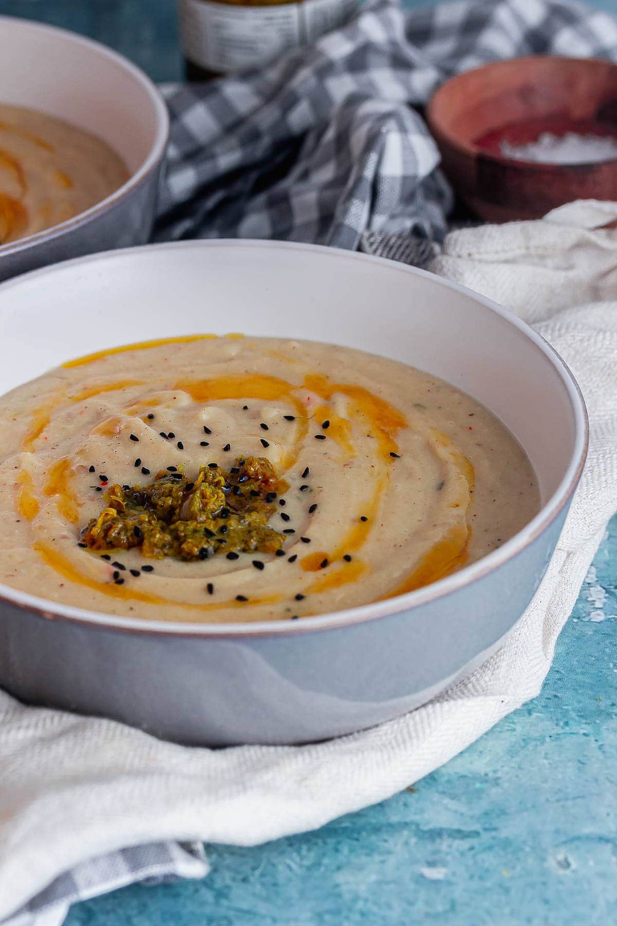 Grey bowl of soup on a blue surface