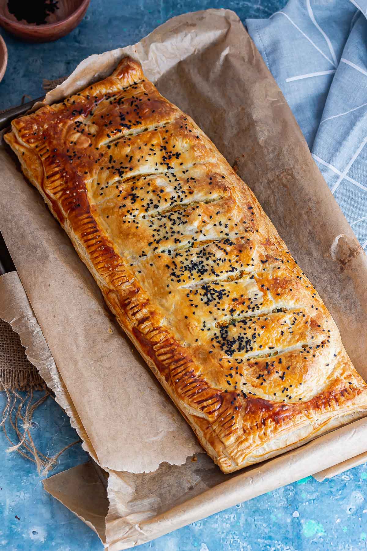 Vegetarian roll on a baking sheet on a blue surface