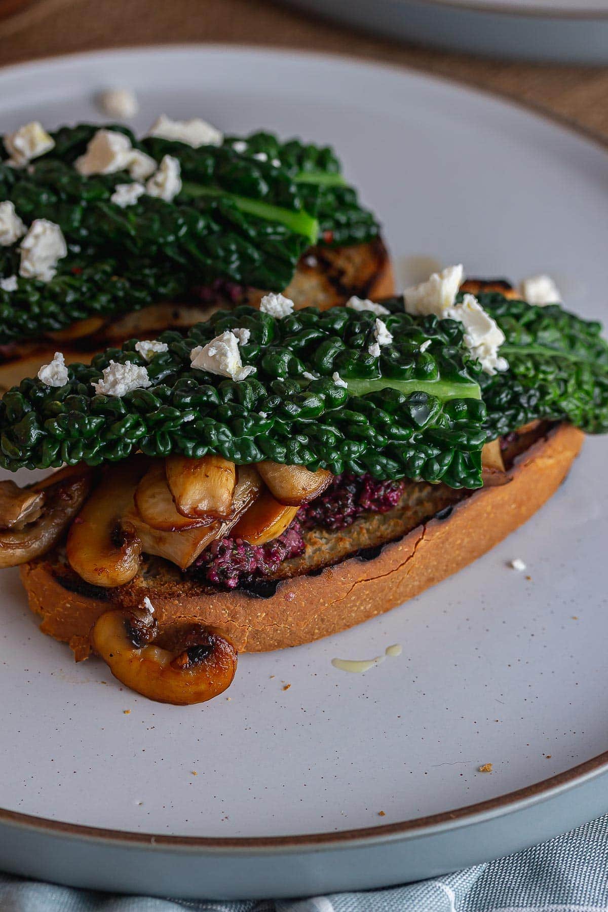 Close up of mushrooms on toast topped with cavolo nero