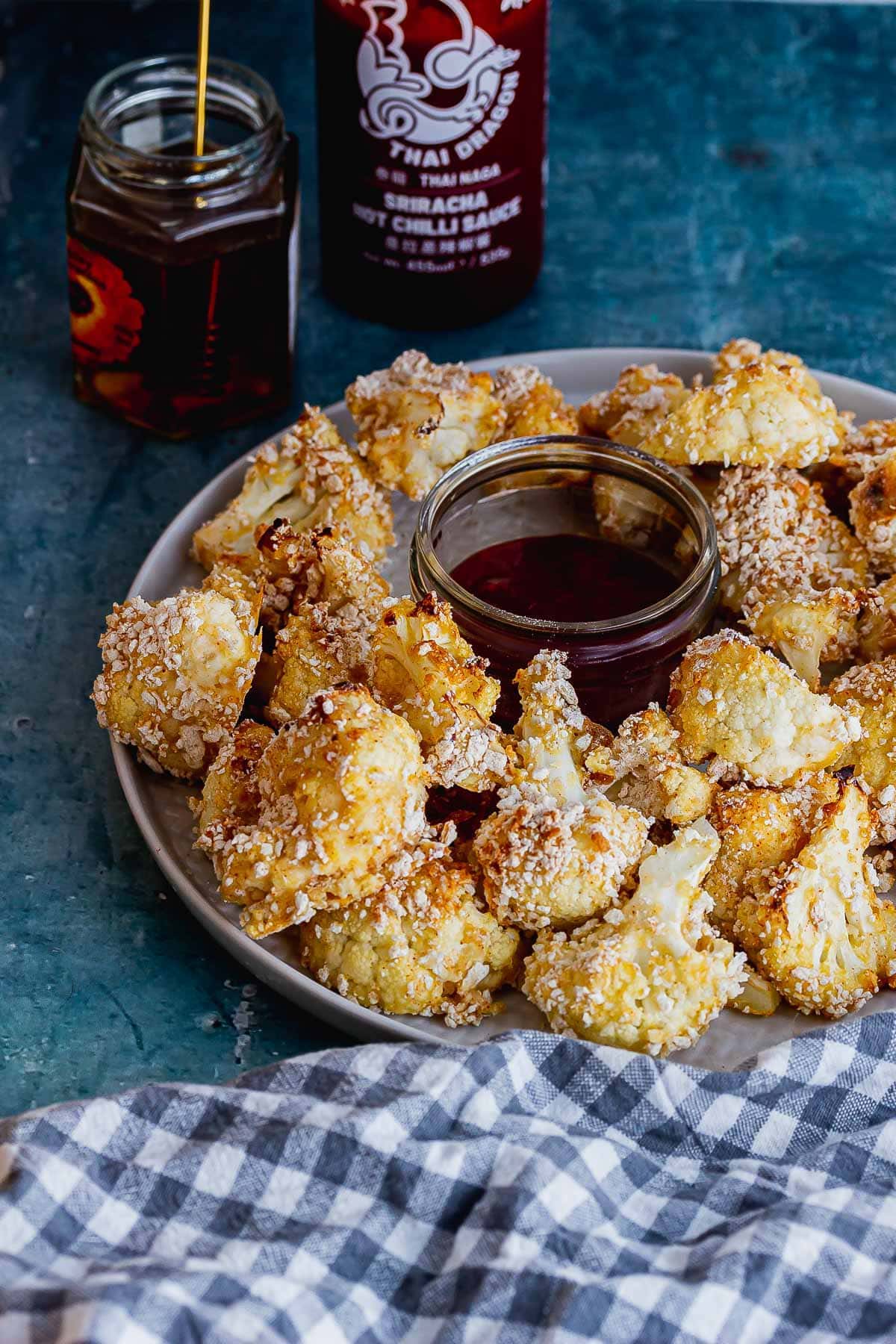 Plate of cauliflower bites with a checked cloth and honey