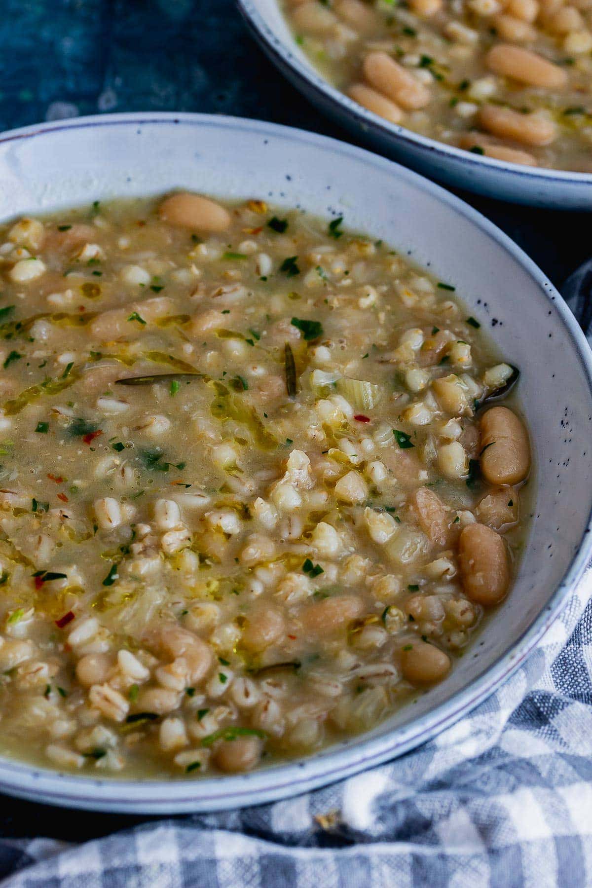 Close up of pearl barley and bean soup in a blue bowl