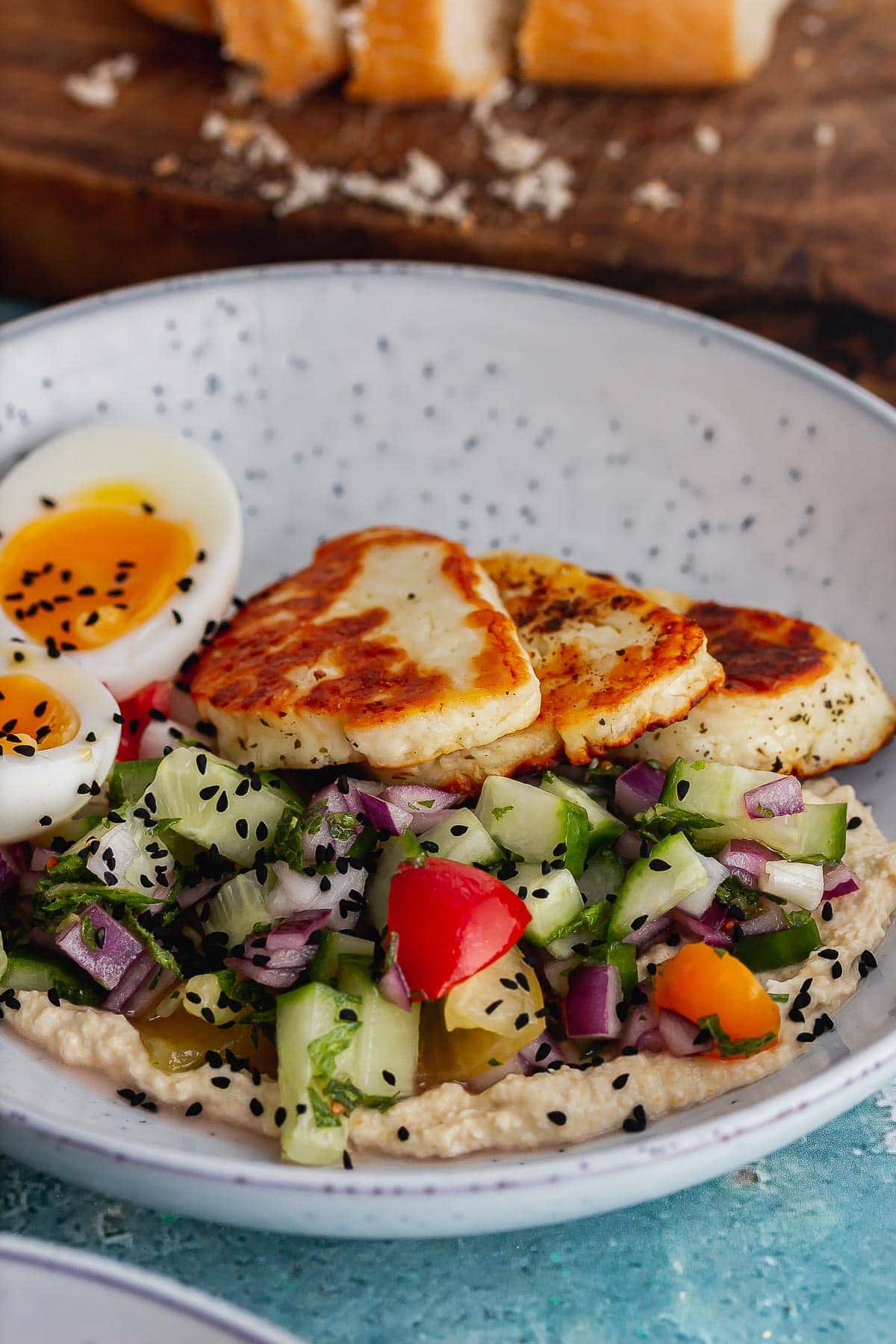 Blue speckled bowls with halloumi, hummus and salad
