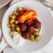 Overhead shot of spicy meatballs and potatoes on a marble background