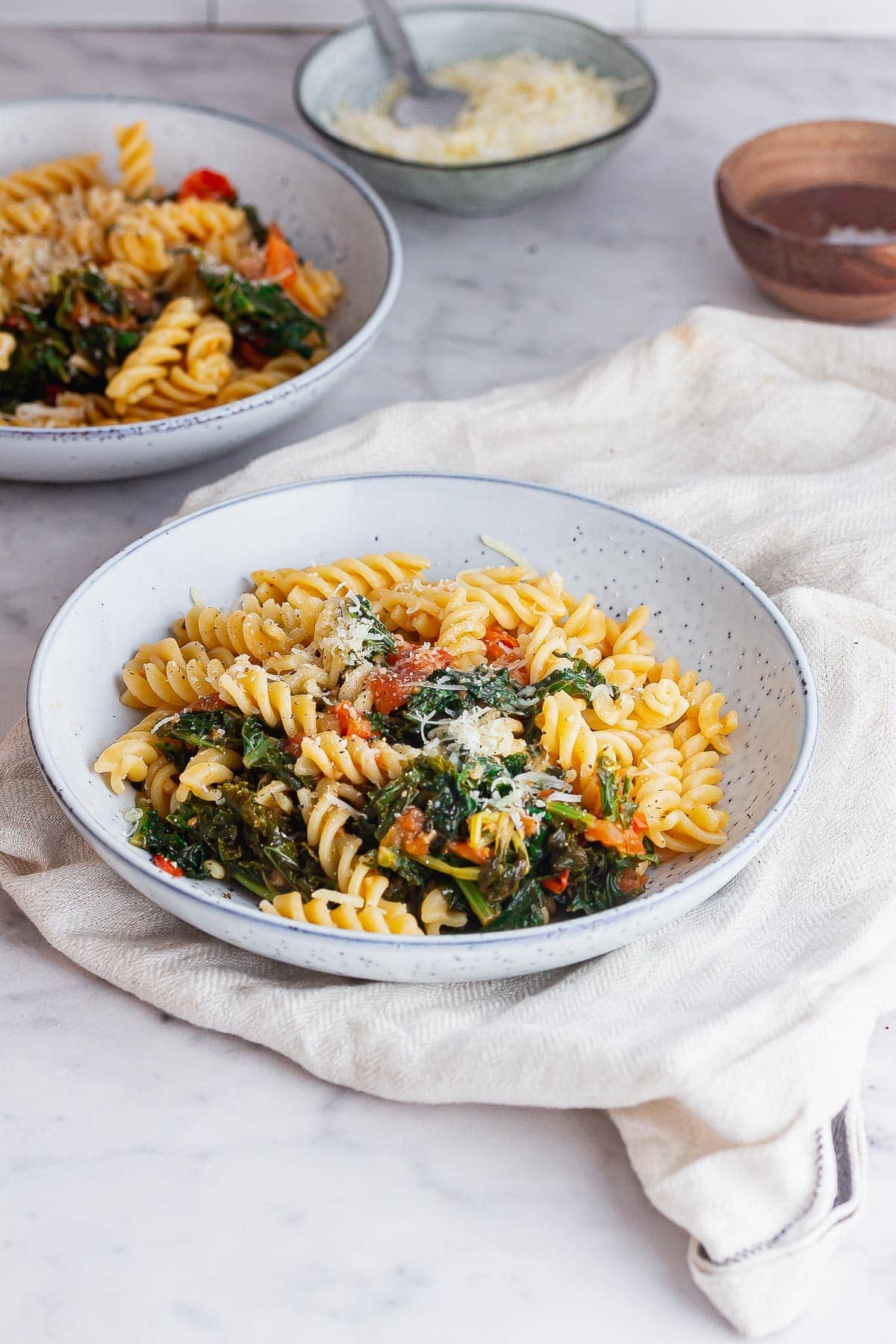 Cherry tomato pasta in a blue bowl on a marble background