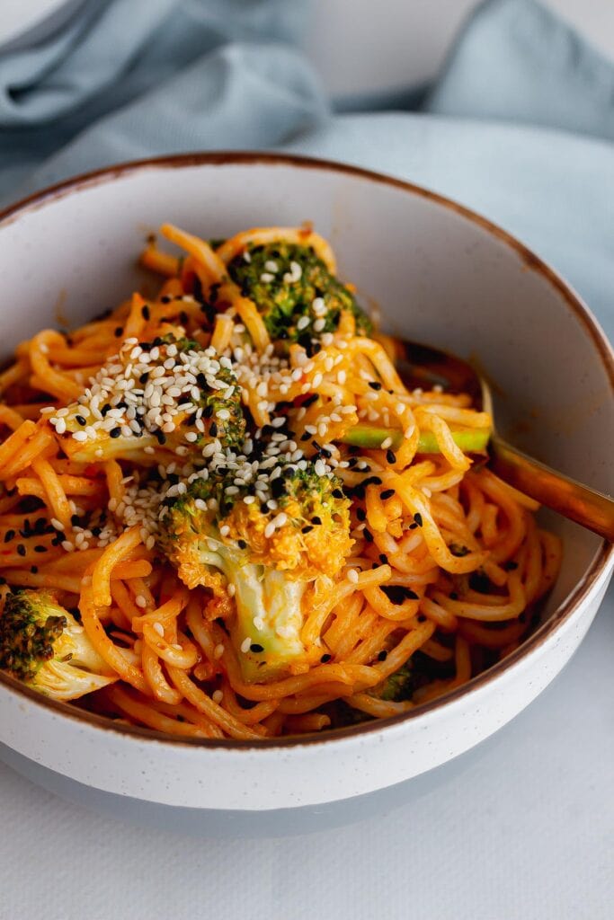 Close up of noodles and broccoli in a grey bowl