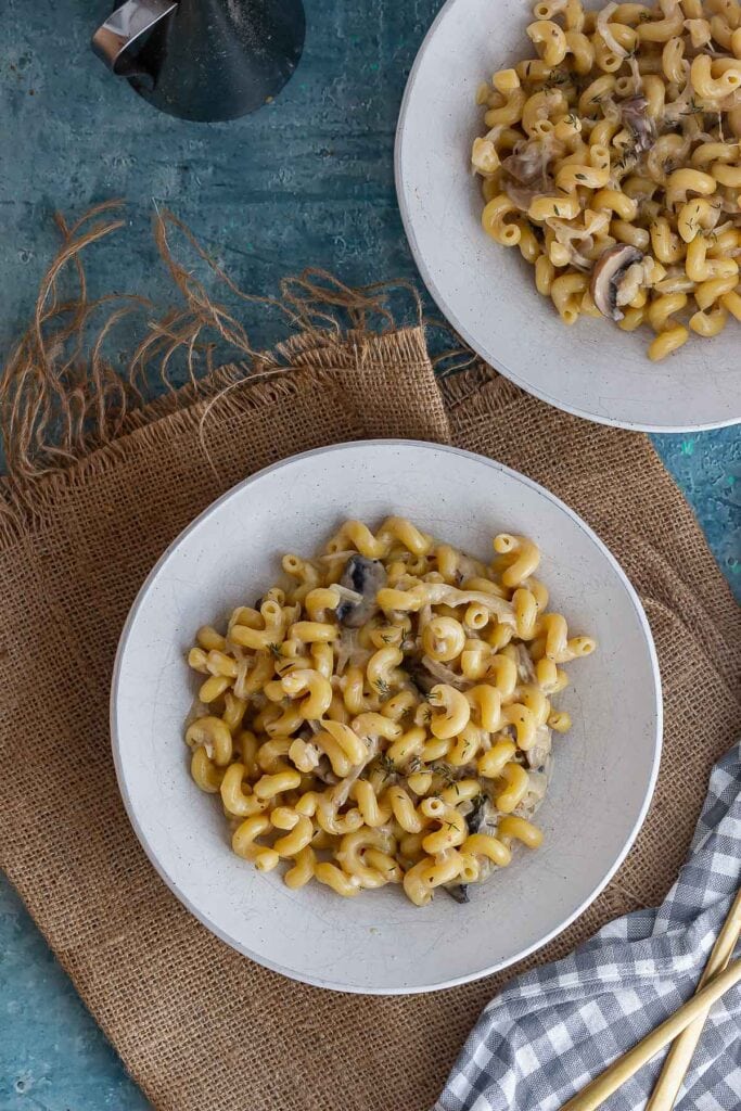 Overhead shot of bowls of pasta on a blue background