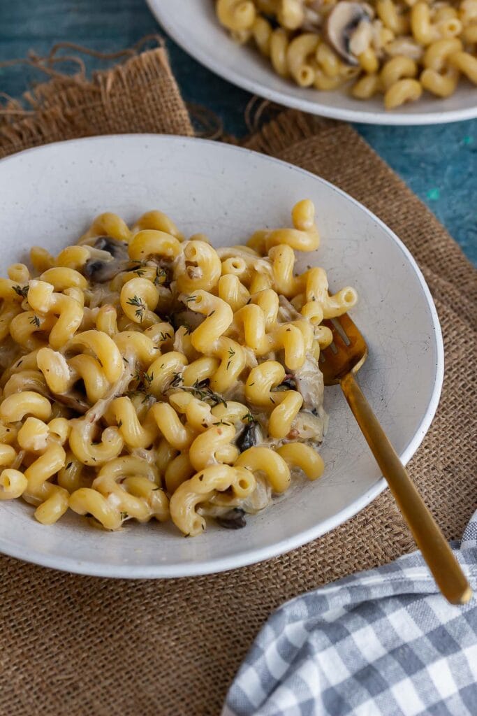 White bowl of pasta with a checked cloth