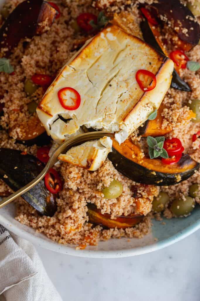 Close up of feta and couscous salad with a gold fork