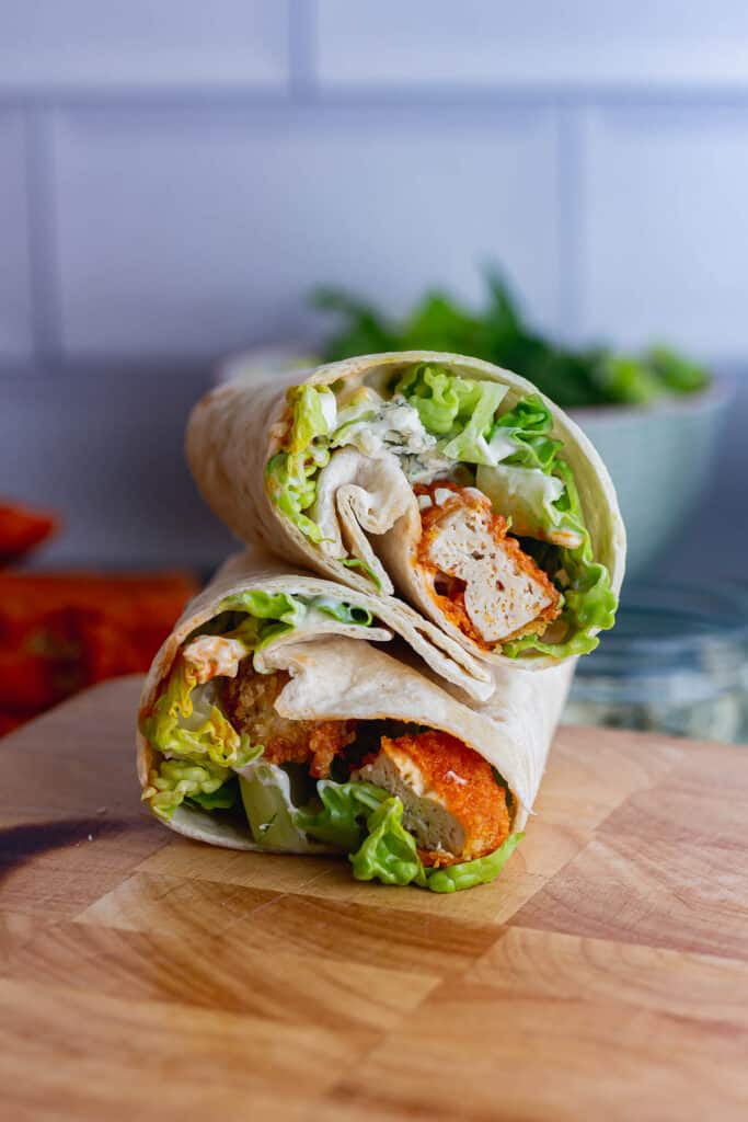 Tofu and salad wrapped in a tortilla on a wooden board