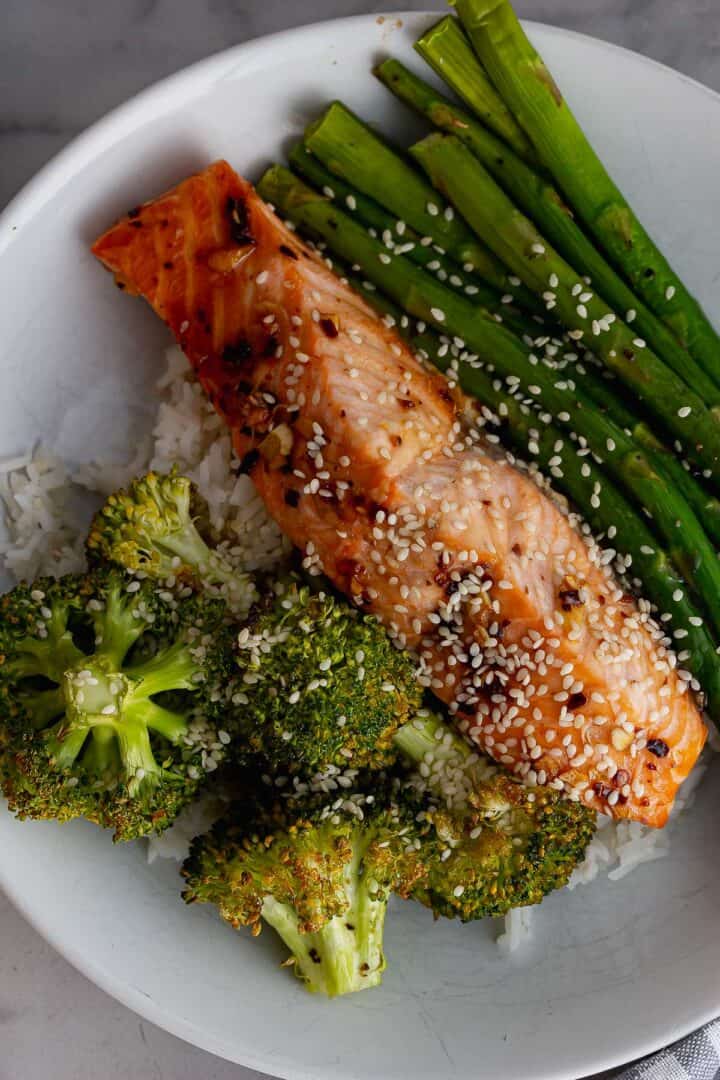 Close up of salmon and vegetables on top of rice