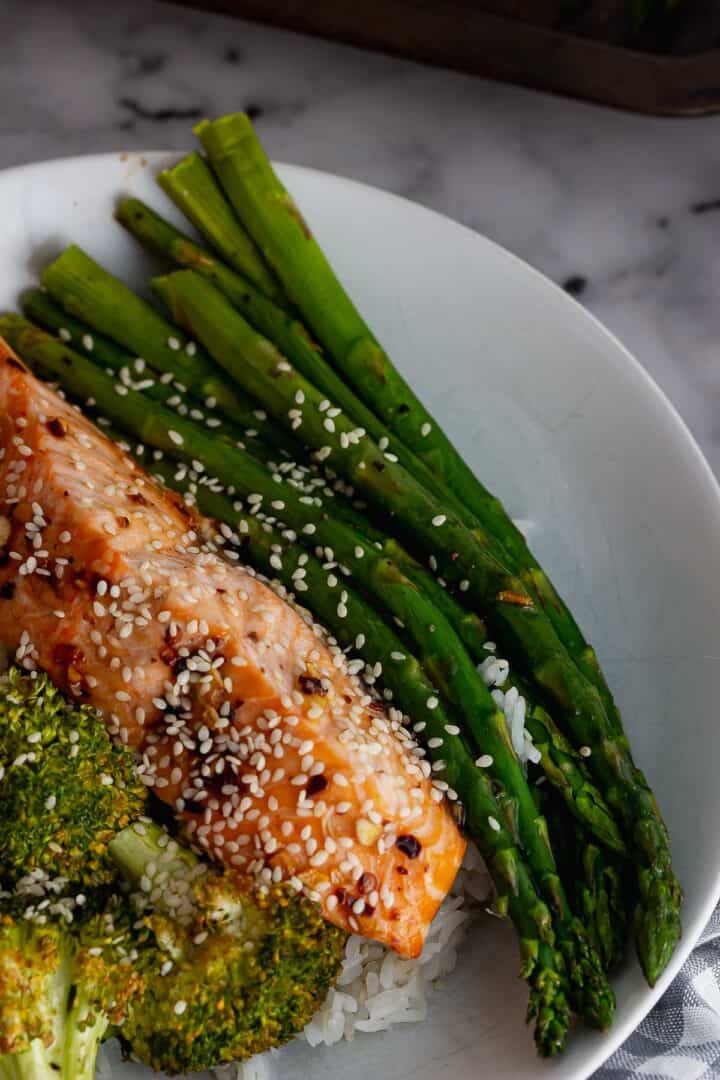 Close up of asparagus with salmon in a white bowl