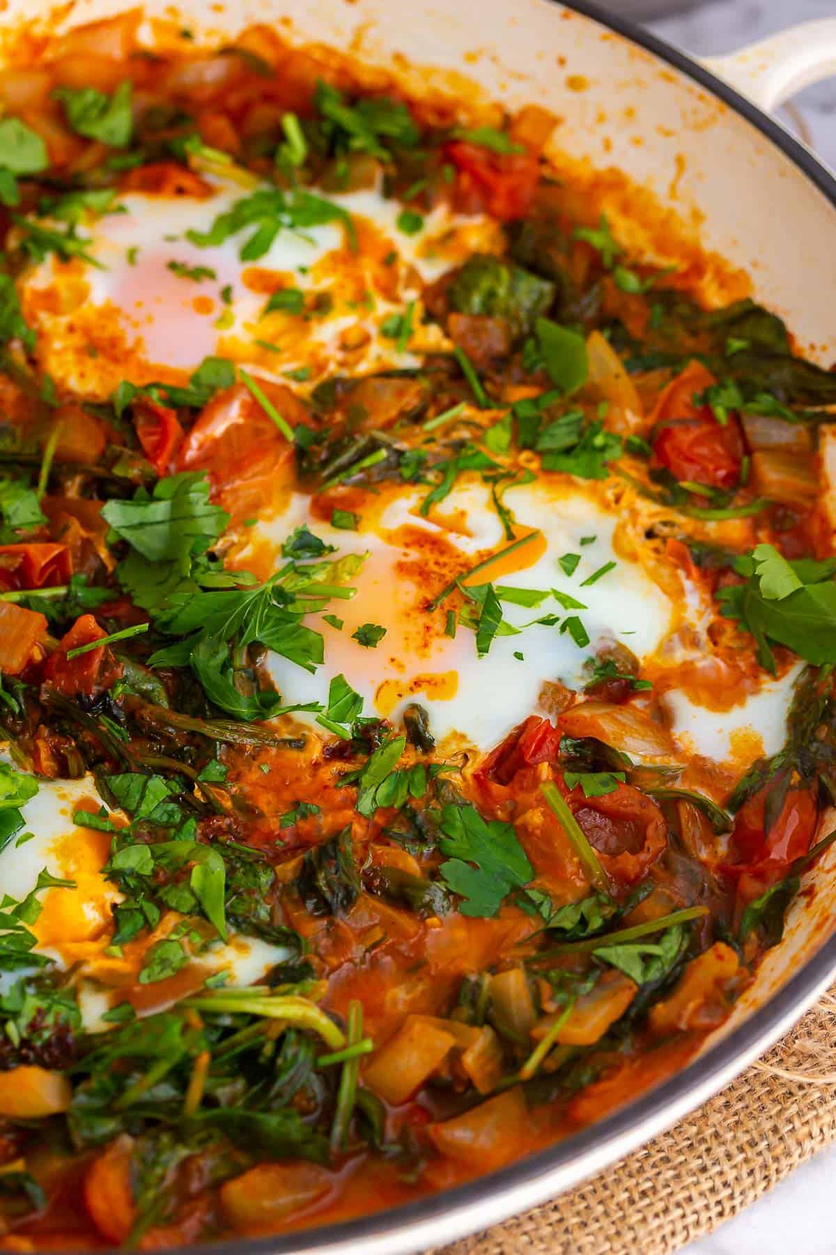 Close up of eggs and tomatoes in a white dish