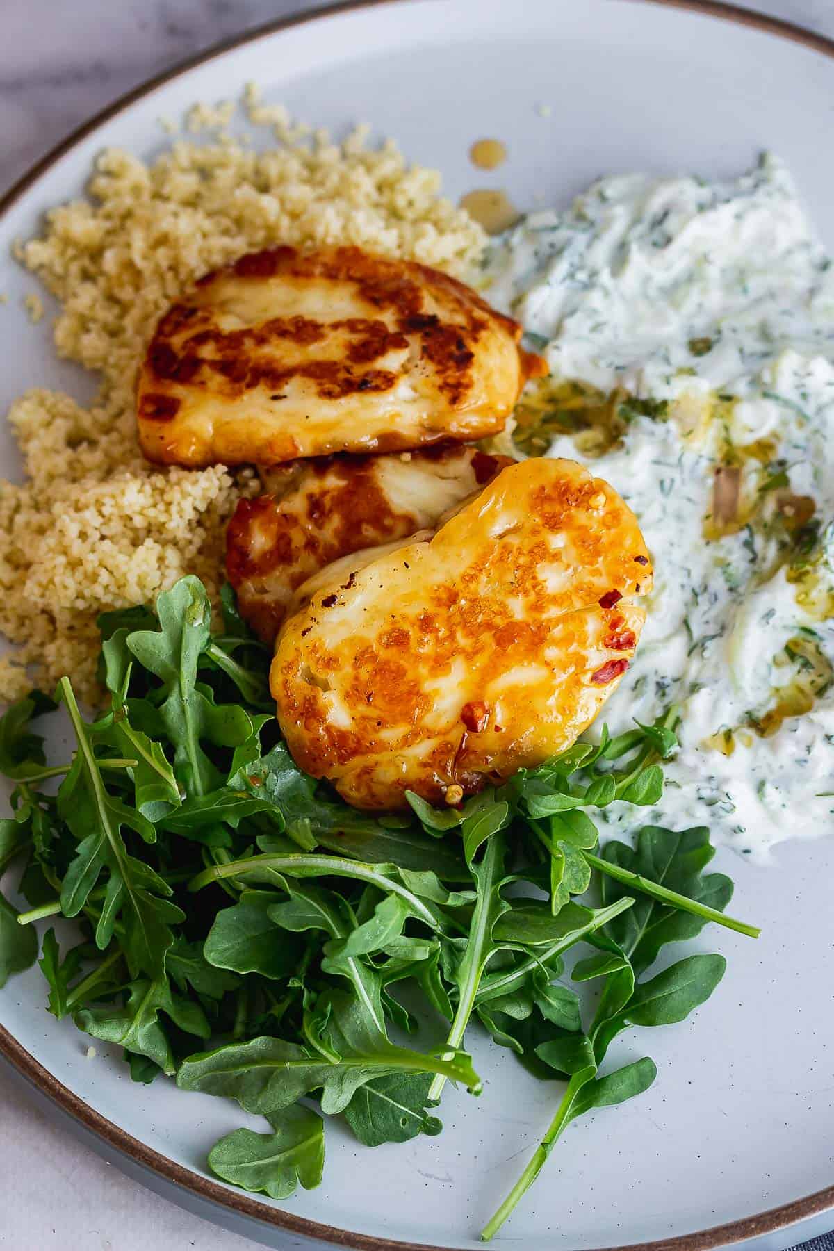 Overhead close up of hot honey halloumi on a grey plate