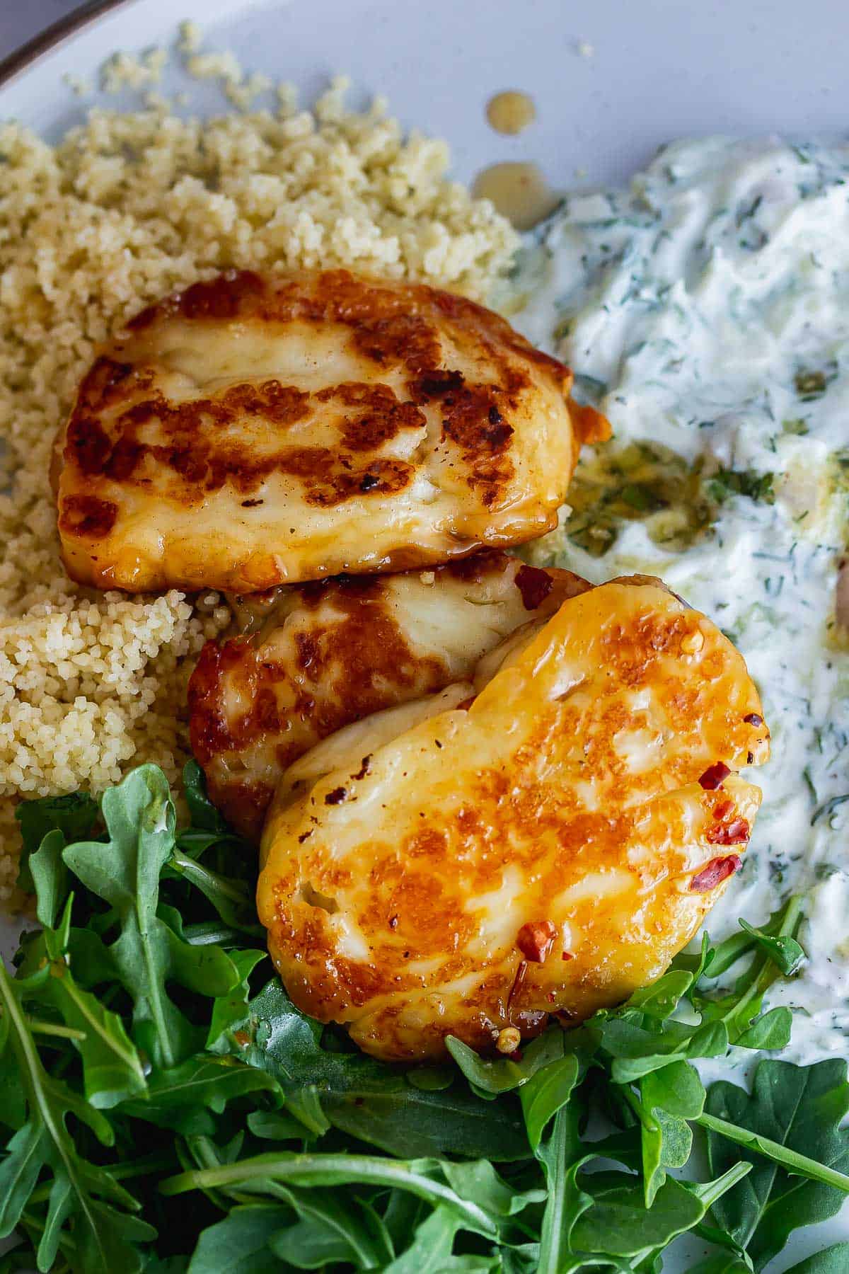 Close up of hot honey halloumi on a bed of rocket