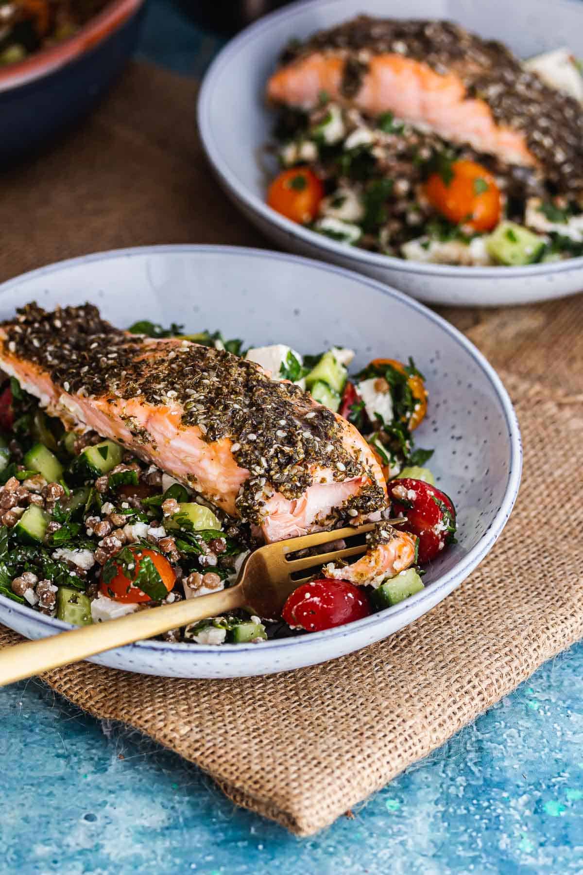 Bowl of couscous with salmon and a gold fork