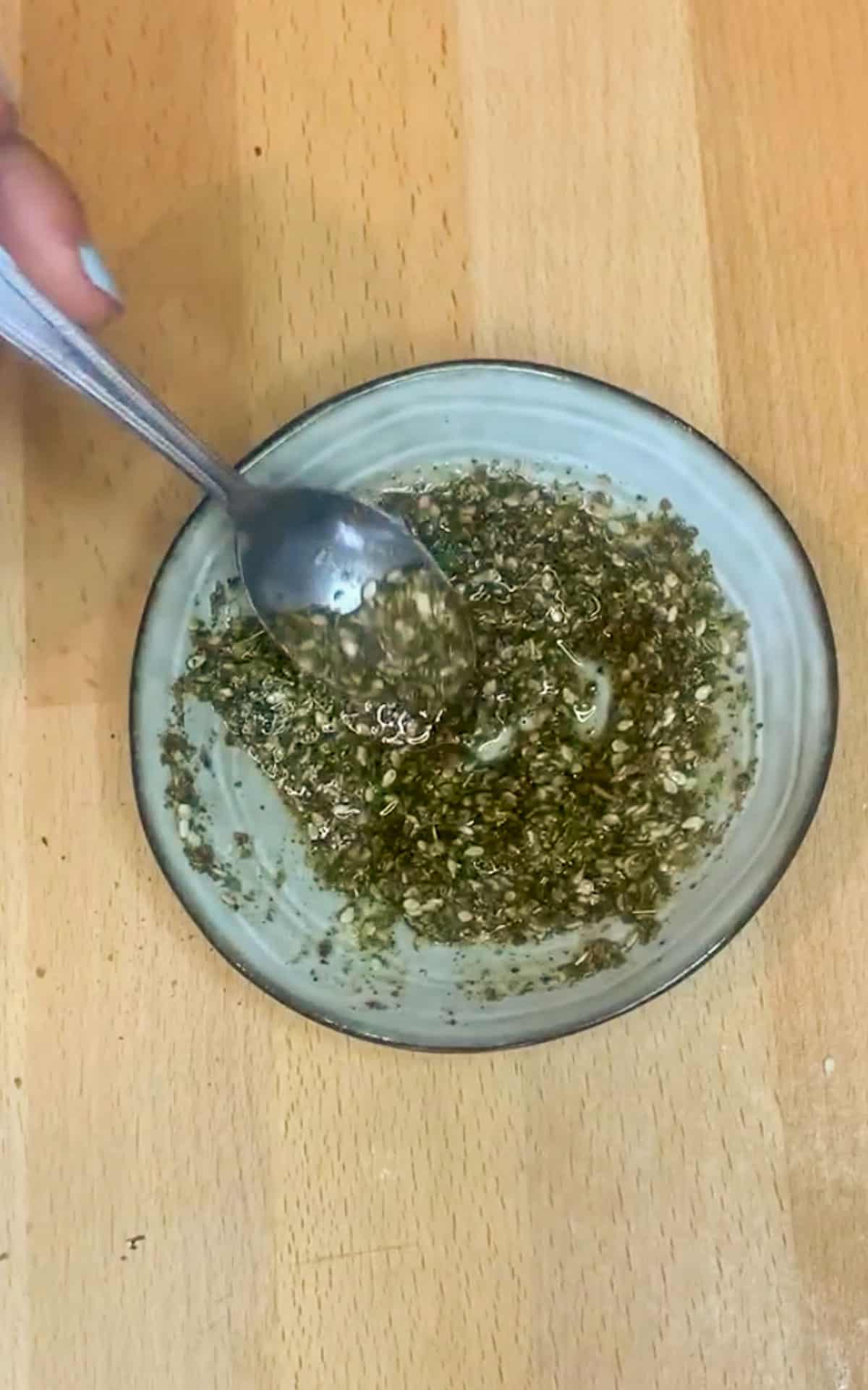 Blue bowl of za'atar and olive oil on a wooden background