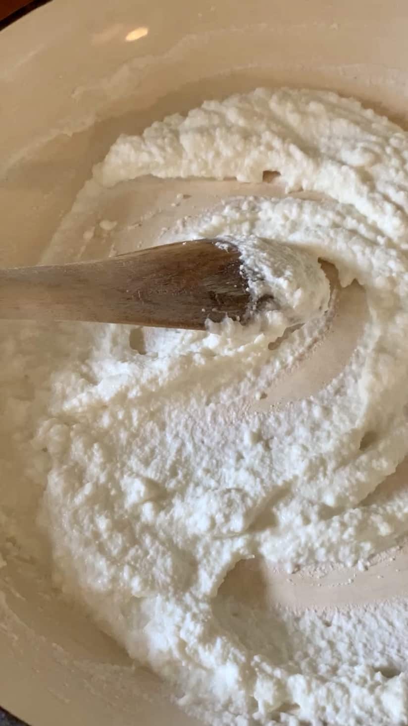 Ricotta in a pan with a wooden spoon