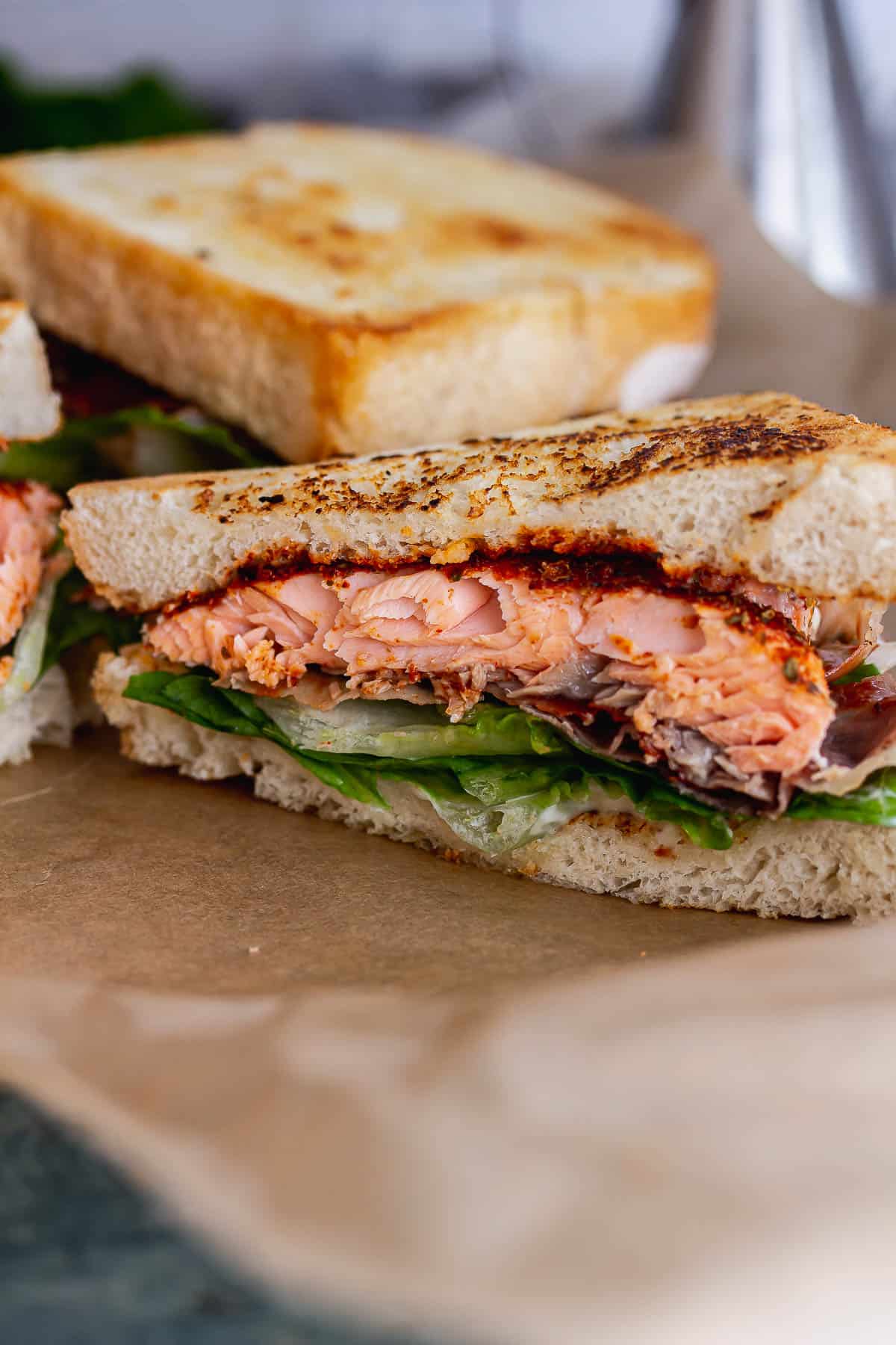 Side on shot of a sandwich with salmon and lettuce