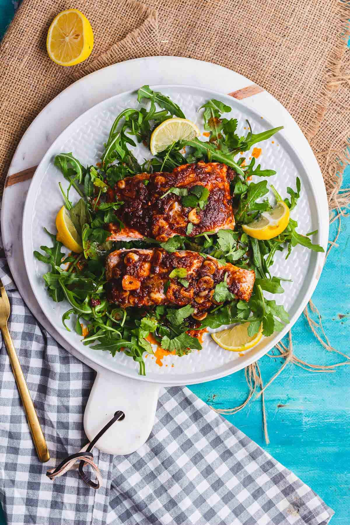 Overhead shot of a plate of salmon on rocket with lemon