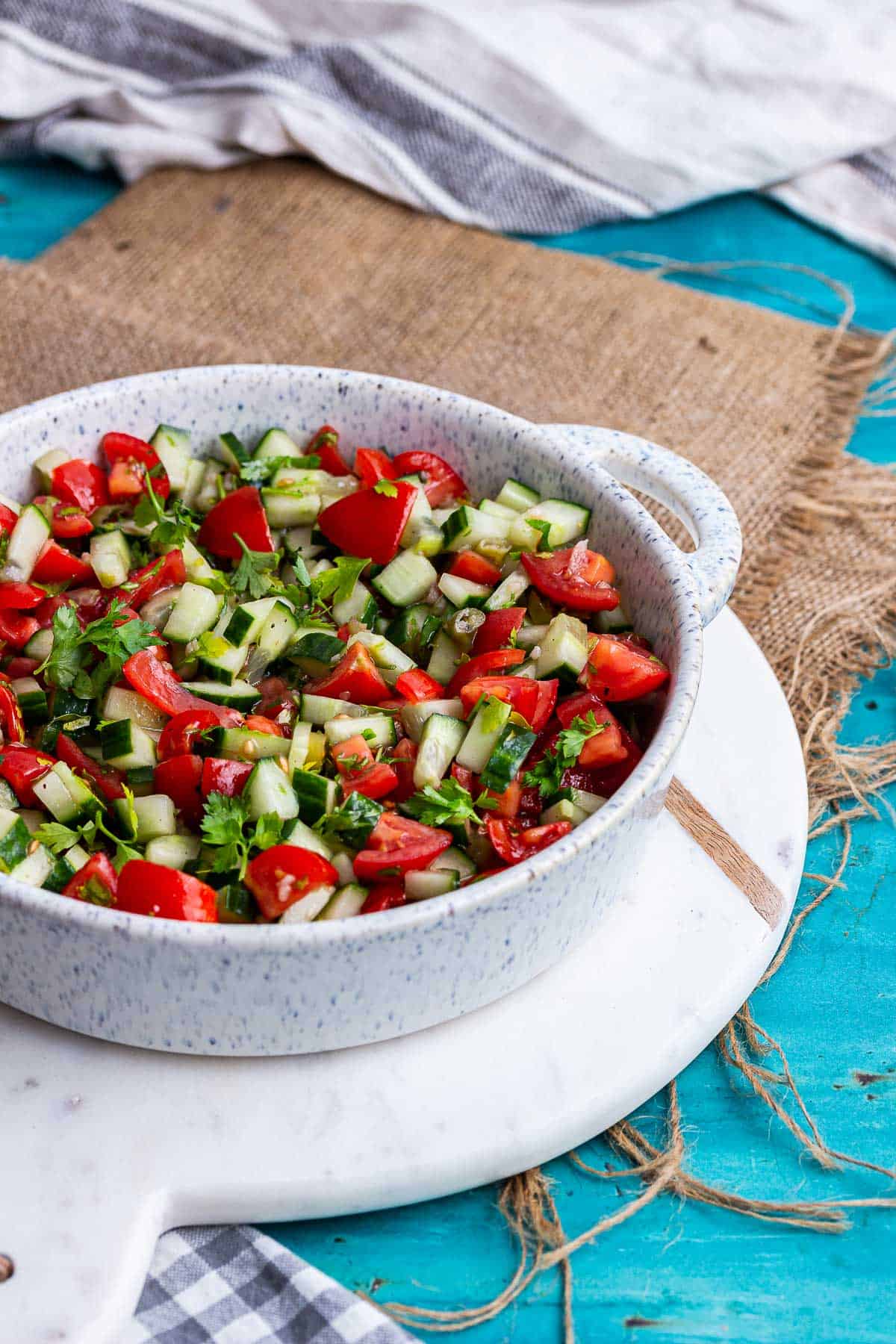 Dish of cucumber and tomato on a blue background