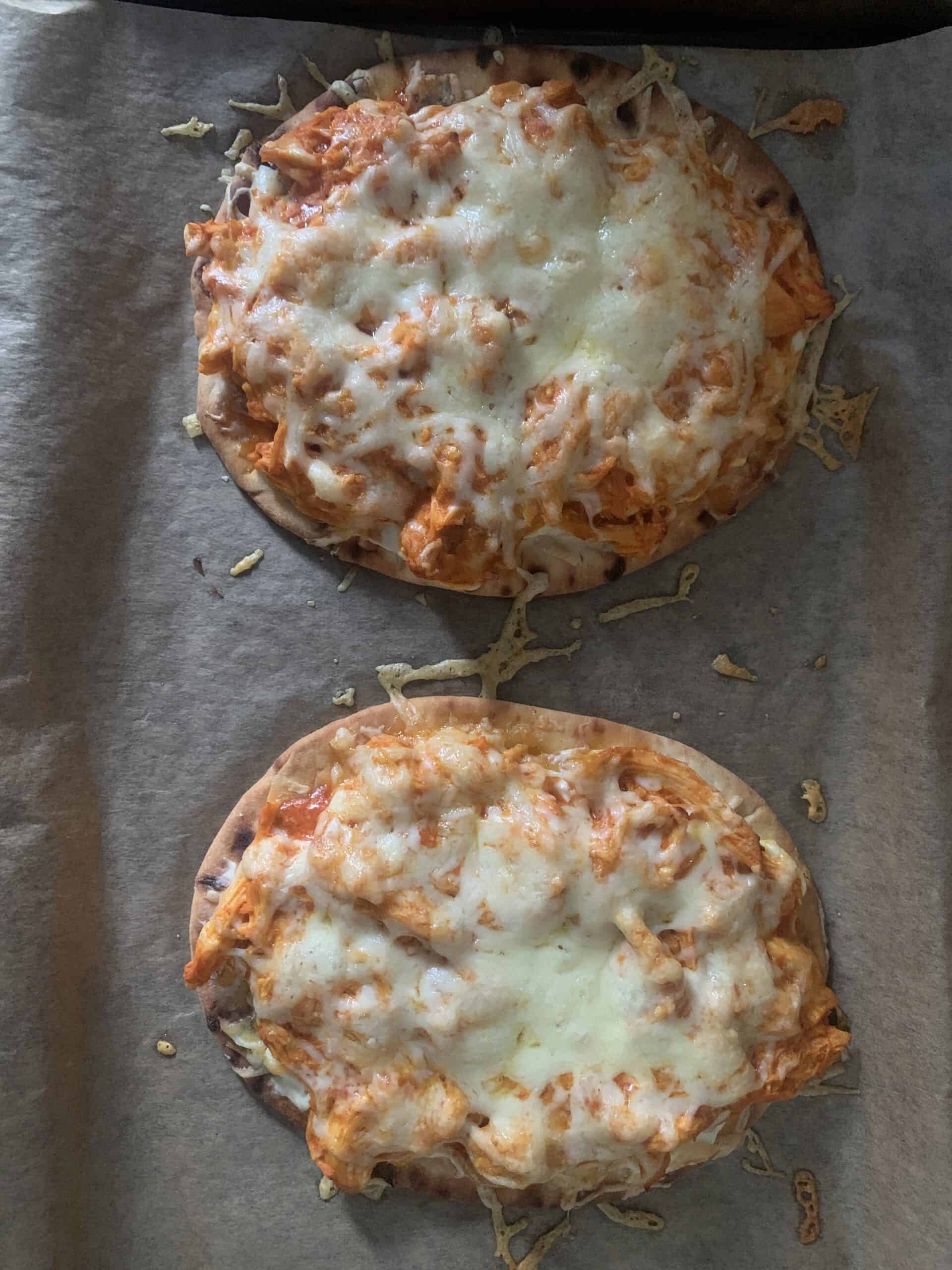 Two flatbreads with chicken and melted cheese